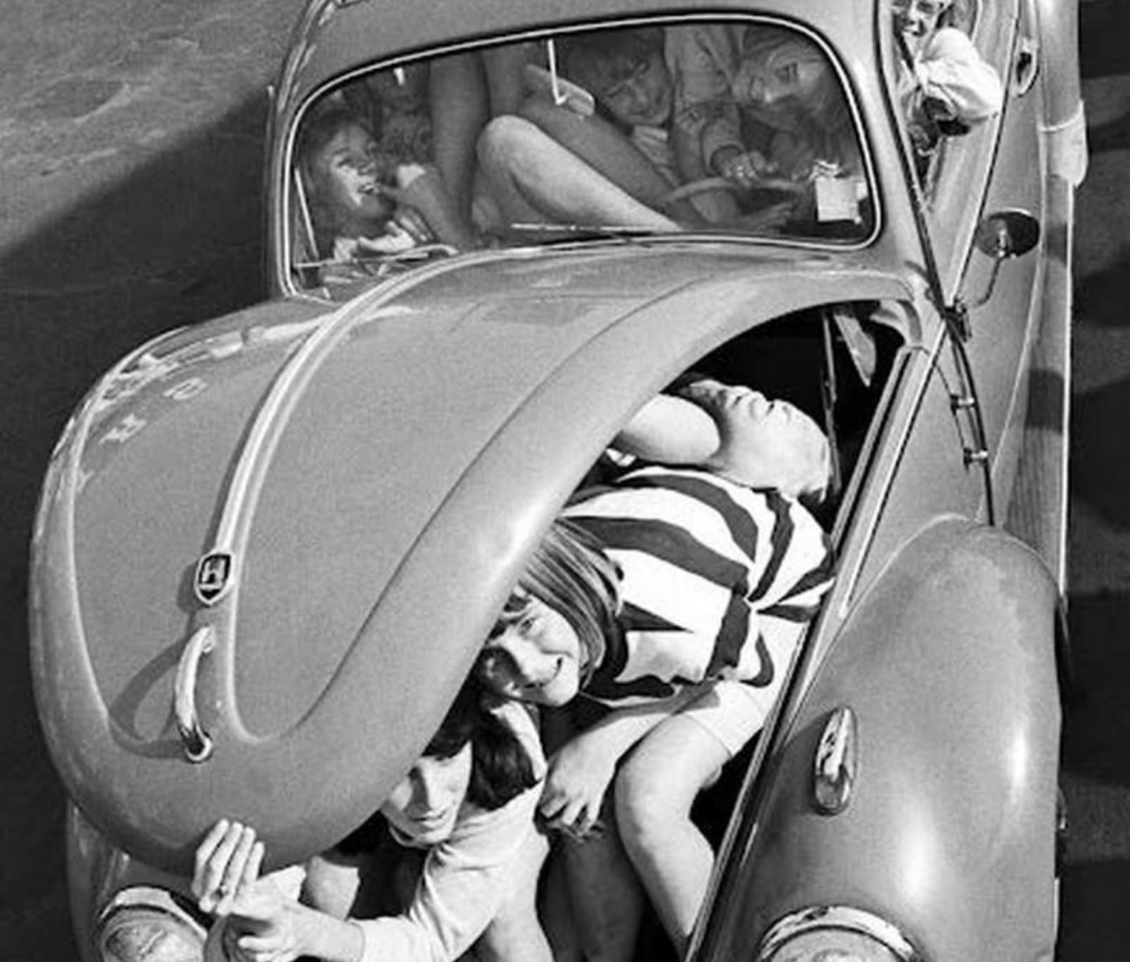 many people in volkwagen beetle - H